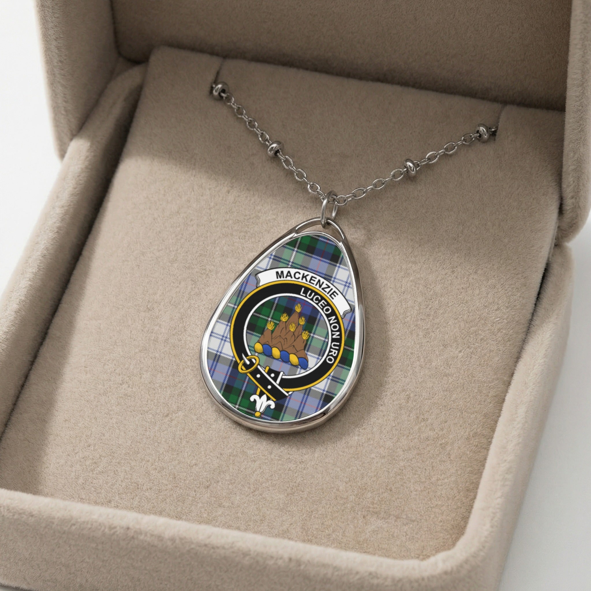 Oval pendant with Mackenzie tartan and crest on a silver chain in a box.