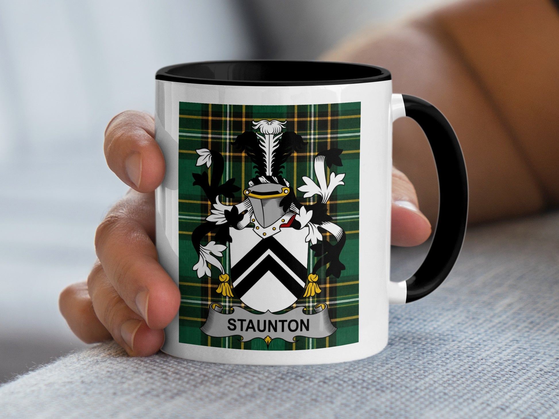 White mug with black rim featuring the STAUNTON coat of arms on a green tartan pattern.