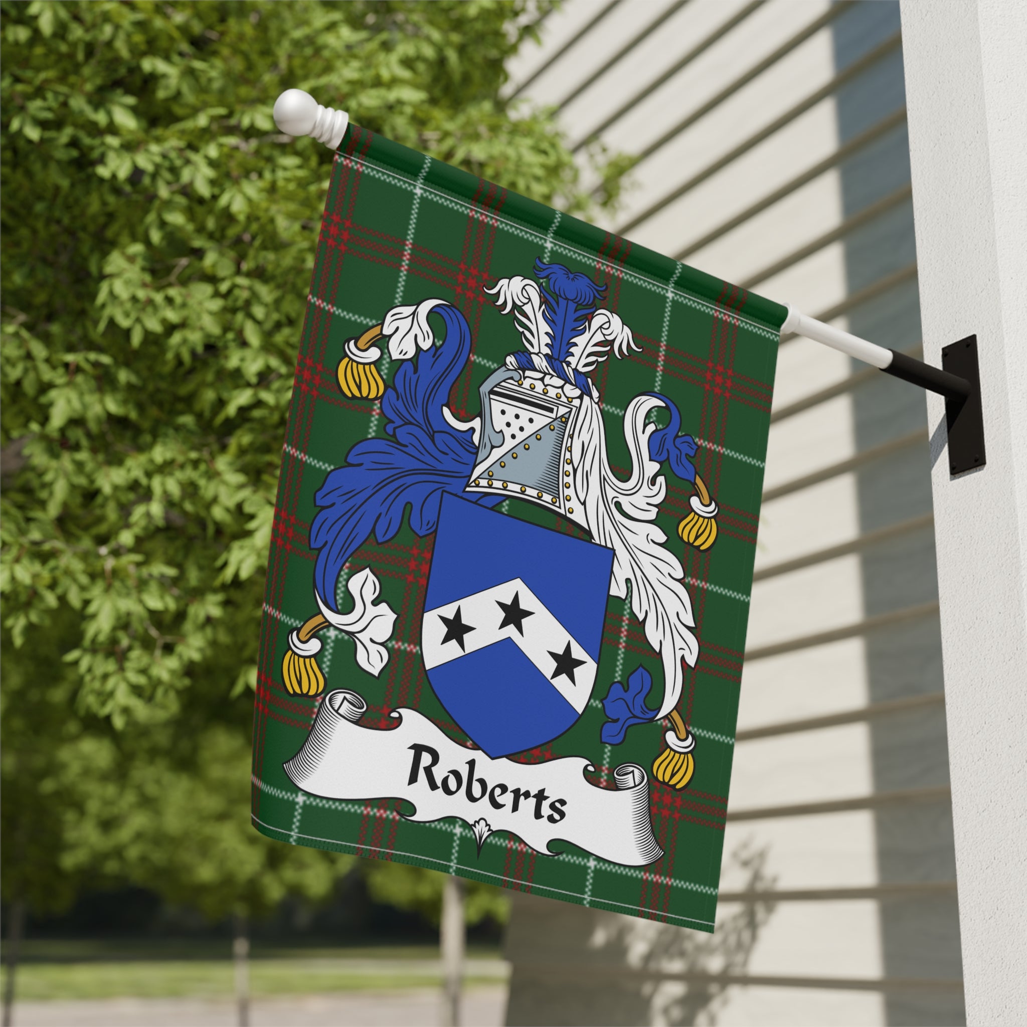 Roberts family crest on a green tartan flag, mounted on a white wall.