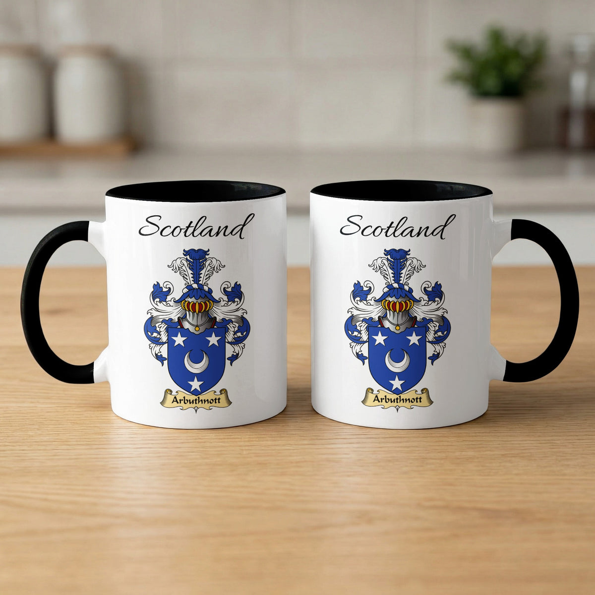 Pair of black-accent Arbuthnott mugs showing the double-sided Scottish family shield design on white ceramic.
