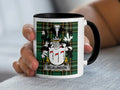 Mug with black handle and rim displaying the McAlindon family crest on a tartan background.