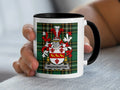 White mug with black rim featuring Waddington family crest on plaid background.