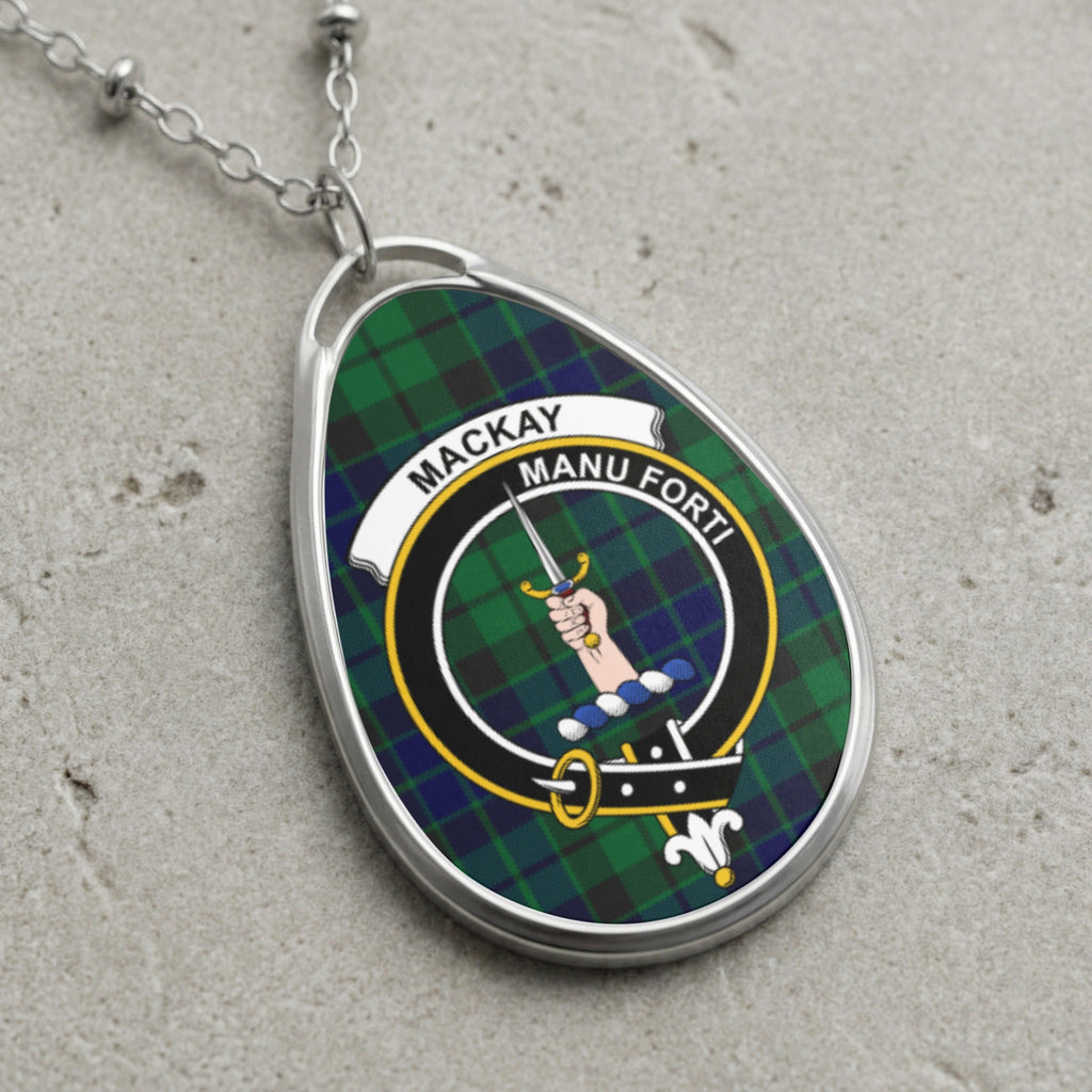 Oval pendant necklace with Mackay clan crest on green and blue plaid background