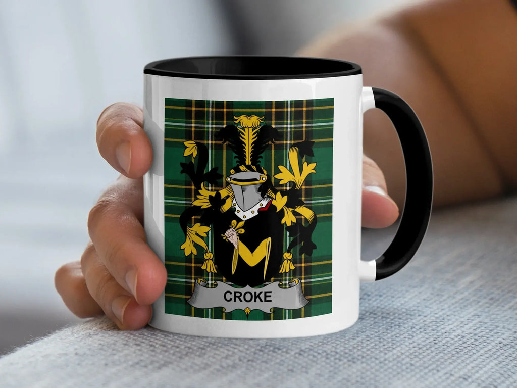 Mug with black rim displaying Croke coat of arms on green tartan background.