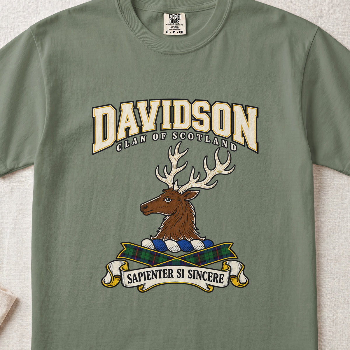 Moss green Davidson Scottish clan T-shirt, front flat lay with cream varsity lettering, stag crest and tartan ribbon.