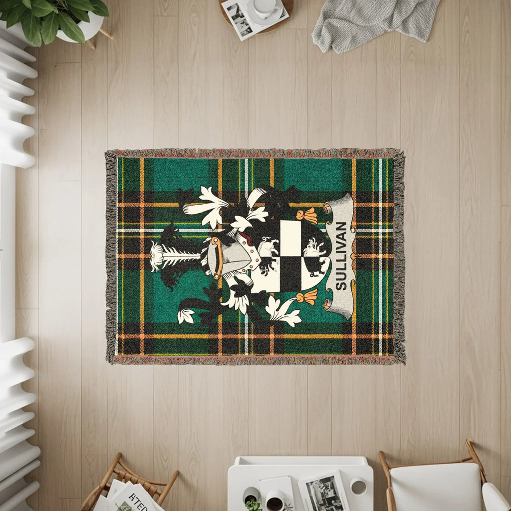 Woven blanket with Sullivan family crest on green tartan plaid.