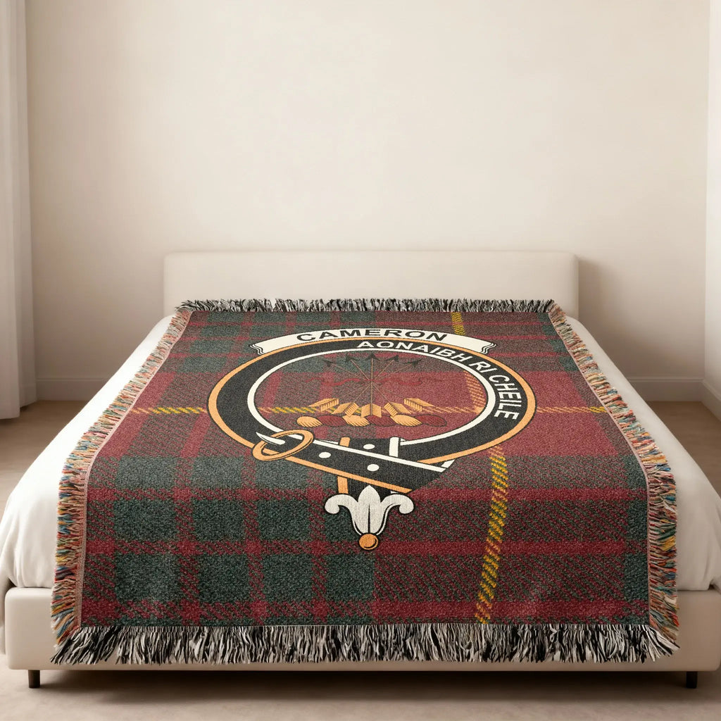 Cameron tartan woven blanket in room setting — clan crest at centre, fringe edge visible