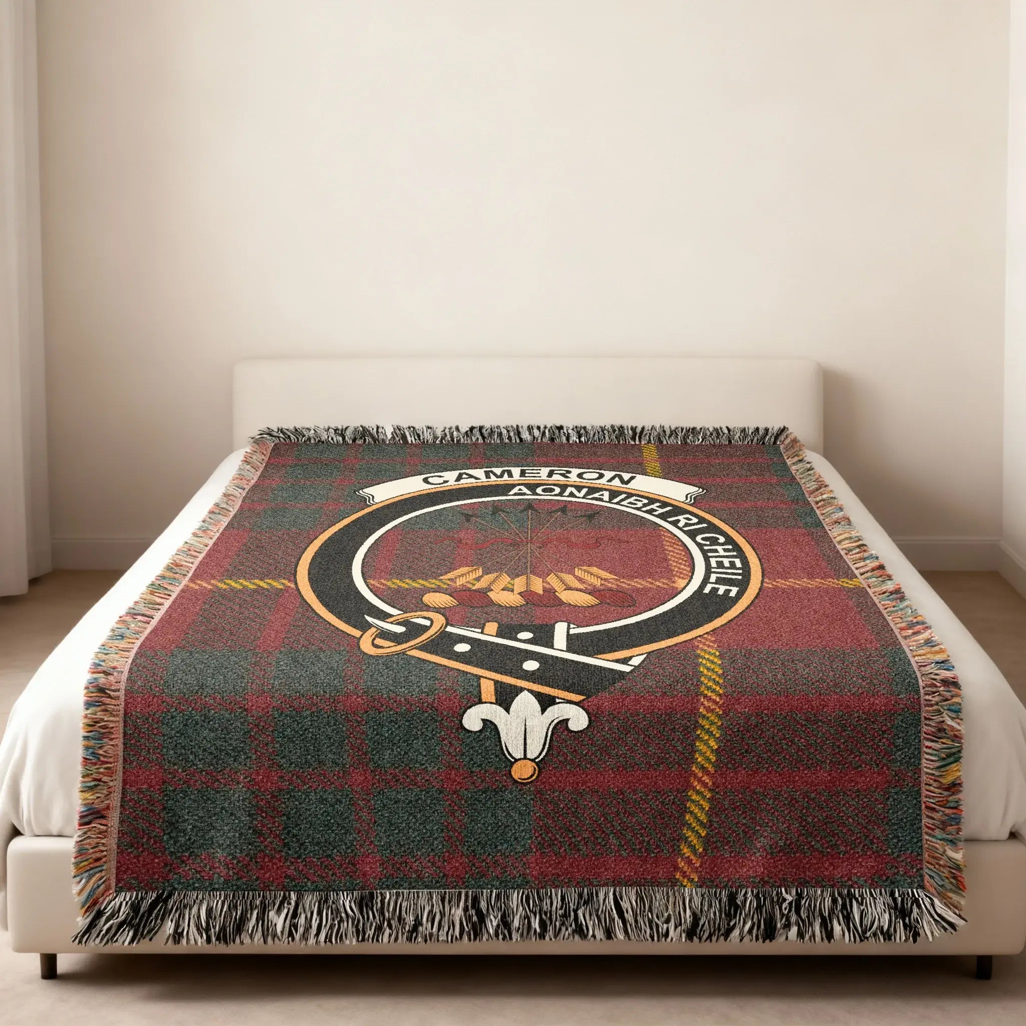 Cameron tartan woven blanket in room setting — clan crest at centre, fringe edge visible