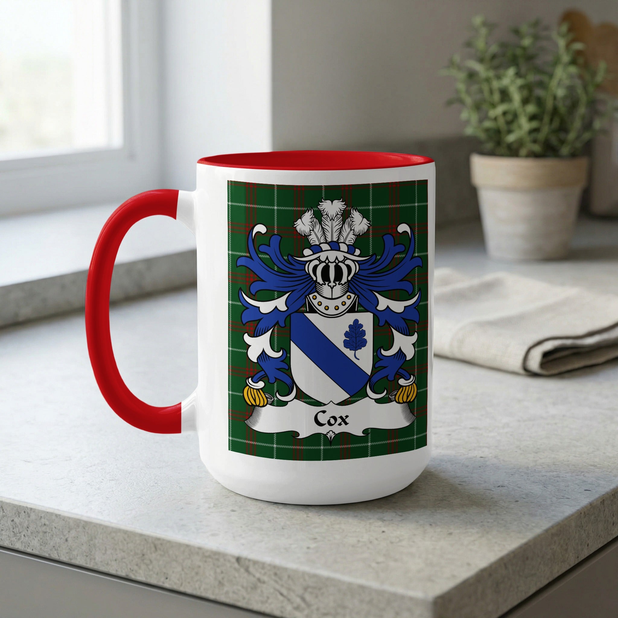 White mug with red handle, featuring the Cox family crest on tartan pattern.