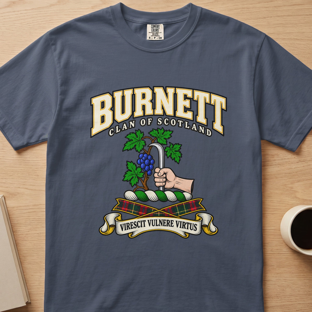 Burnett clan crest with grapevine and pruning hook on a slate blue Comfort Colors T-shirt, front view