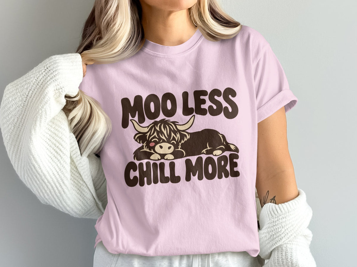 Model wearing the Moo Less, Chill More Highland cow Comfort Colors T-shirt in Blossom