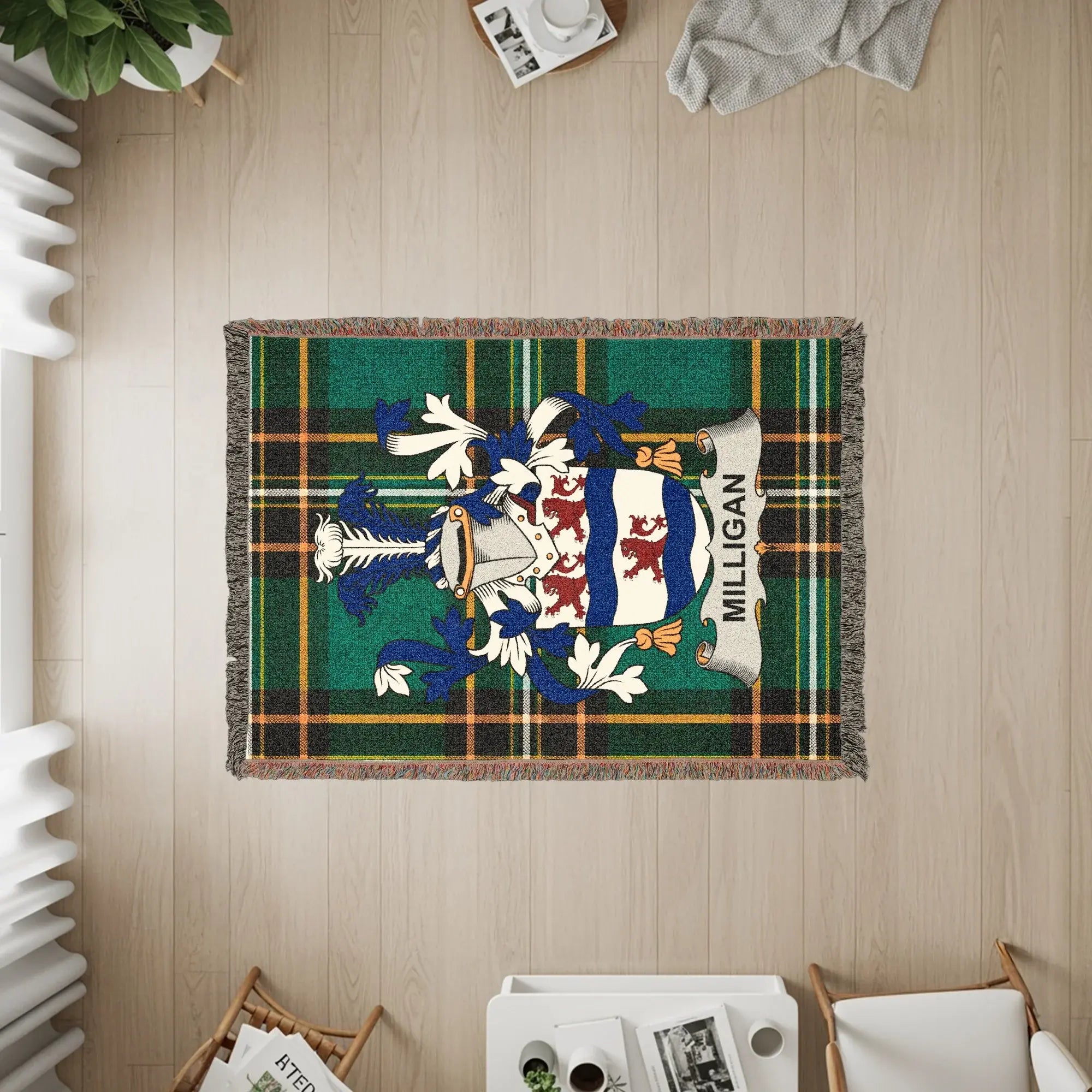 Woven blanket with Milligan family crest on green tartan background.
