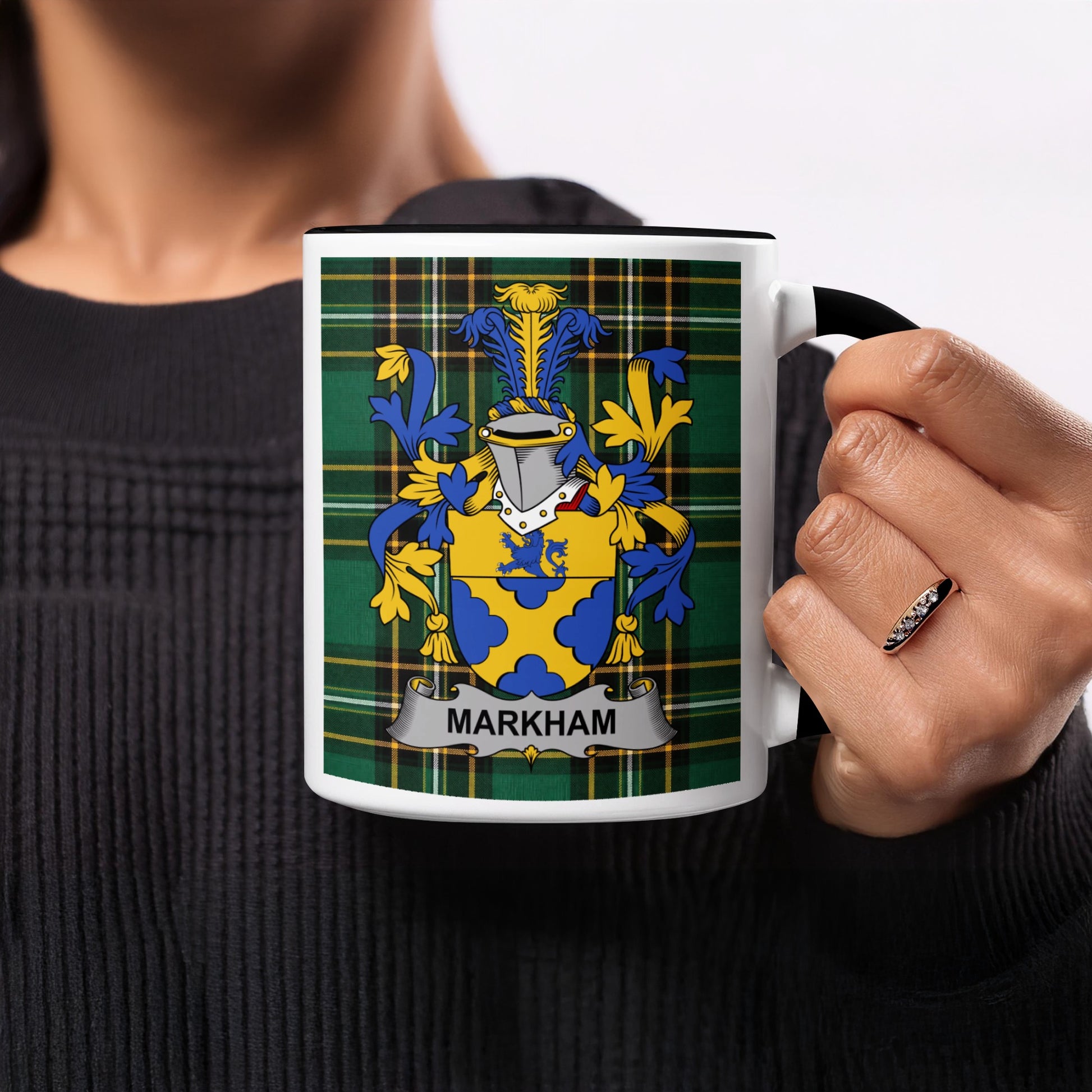 White mug with black rim featuring the Markham coat of arms on a plaid background.
