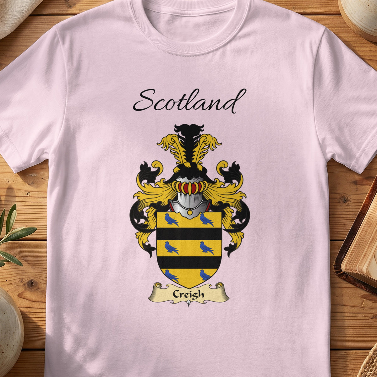 Light Pink Creigh Scottish family shield T-shirt featuring blue birds between black bands on gold