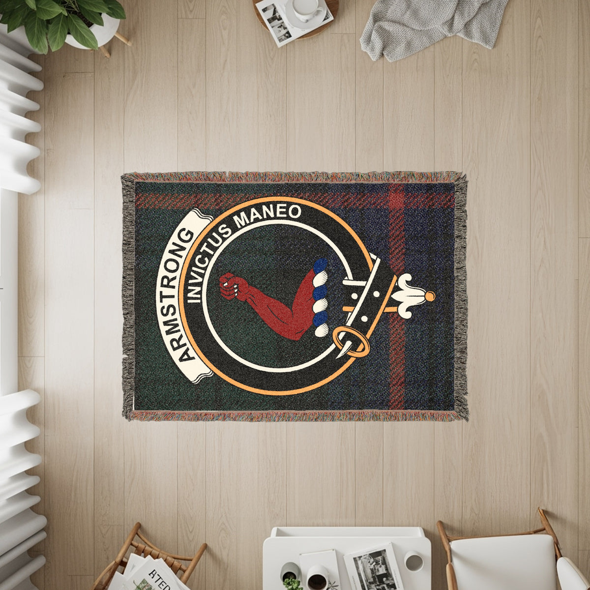 Armstrong woven blanket displayed on a wall, featuring the crest badge and tartan background