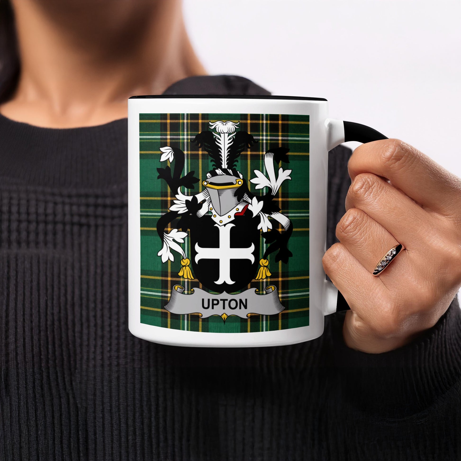 Black mug with the Upton family crest and plaid background.