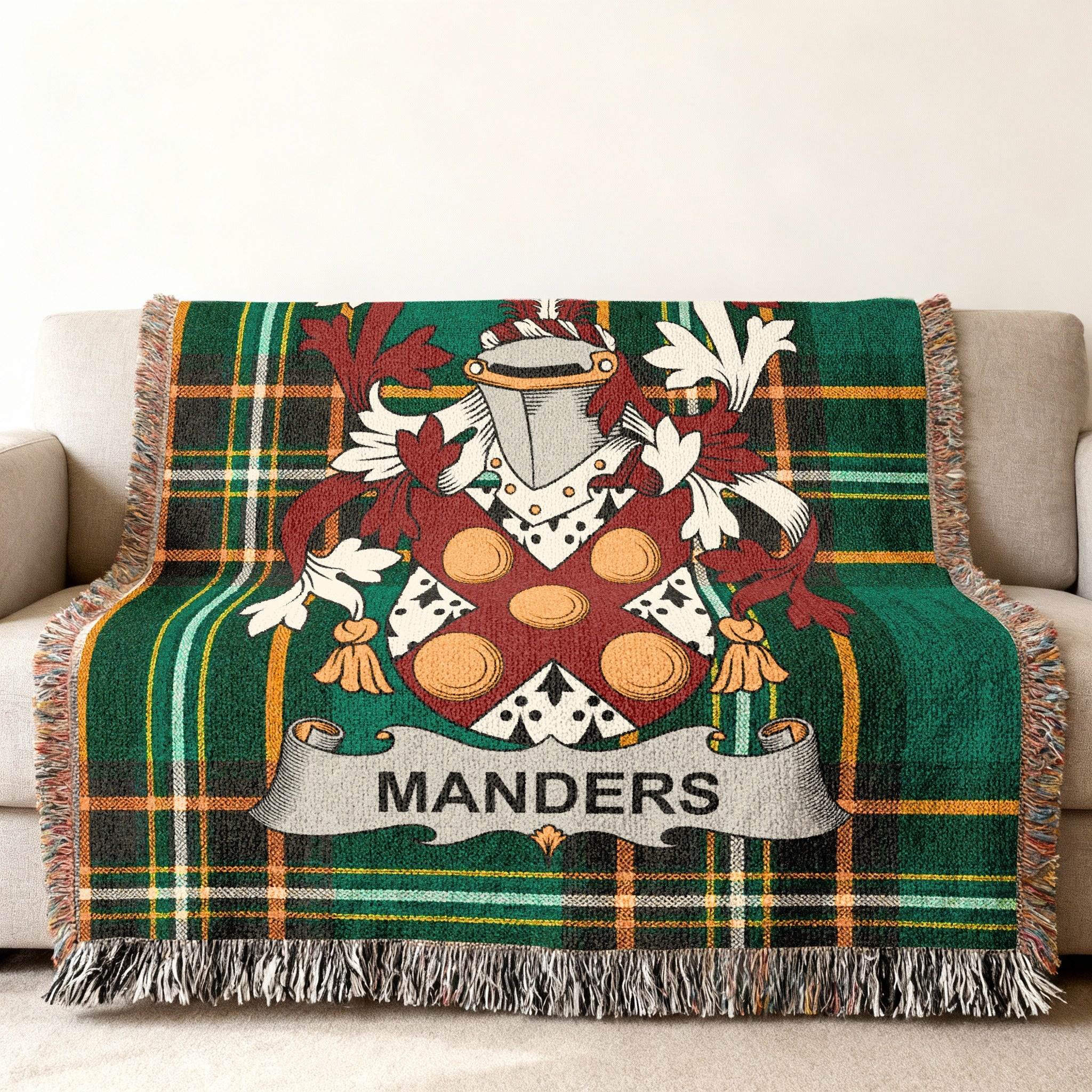 Green tartan blanket with Mander crest draped on a sofa.