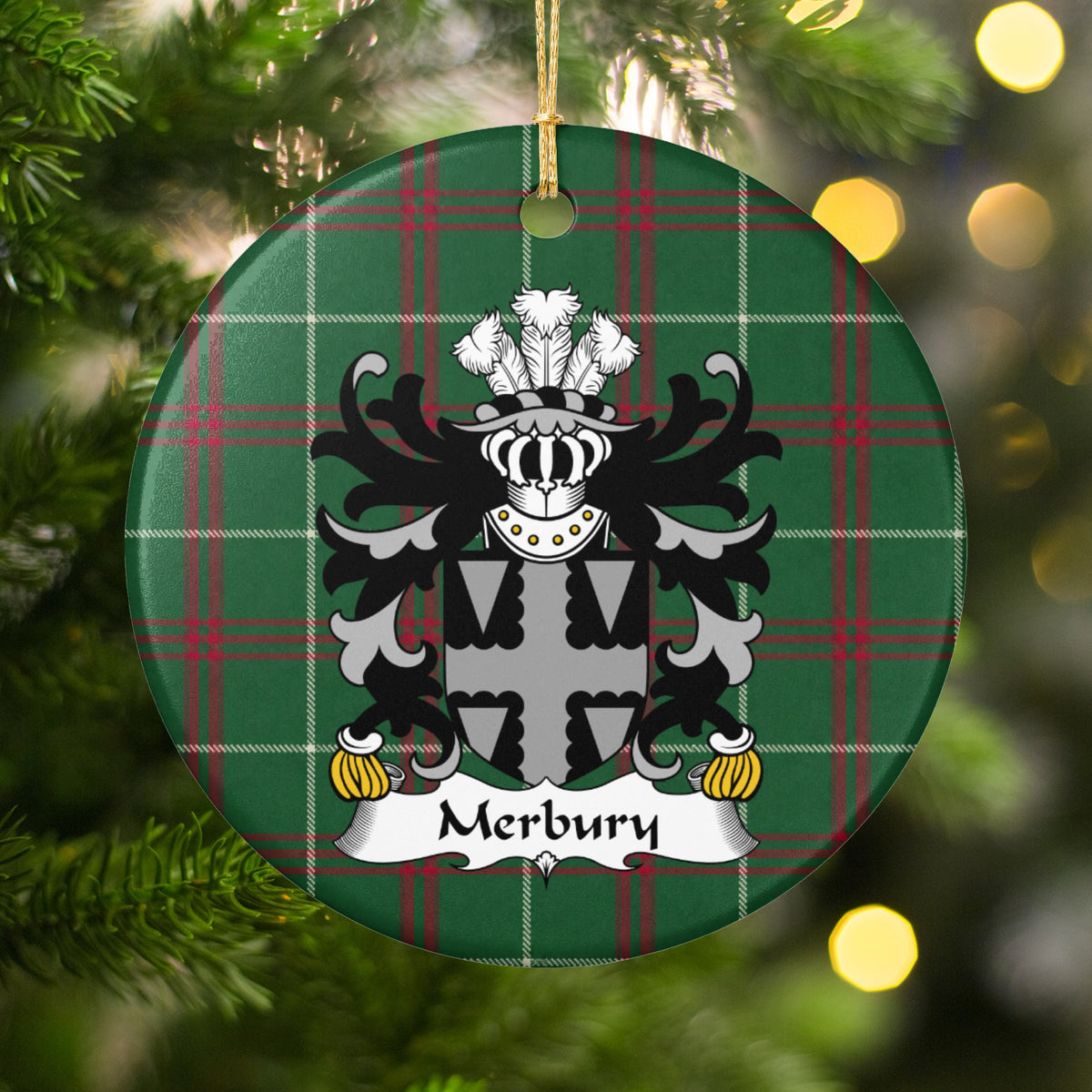 Merbury ornament hanging among Christmas tree branches and warm lights, with a gray-and-black shield with a scalloped cross pattern on Welsh National Tartan.