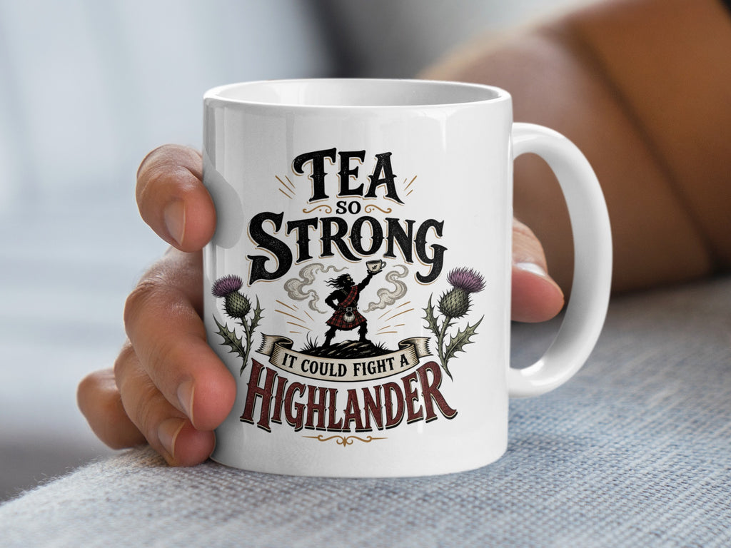 White mug with "Tea so strong it could fight a Highlander" text and Scottish imagery.