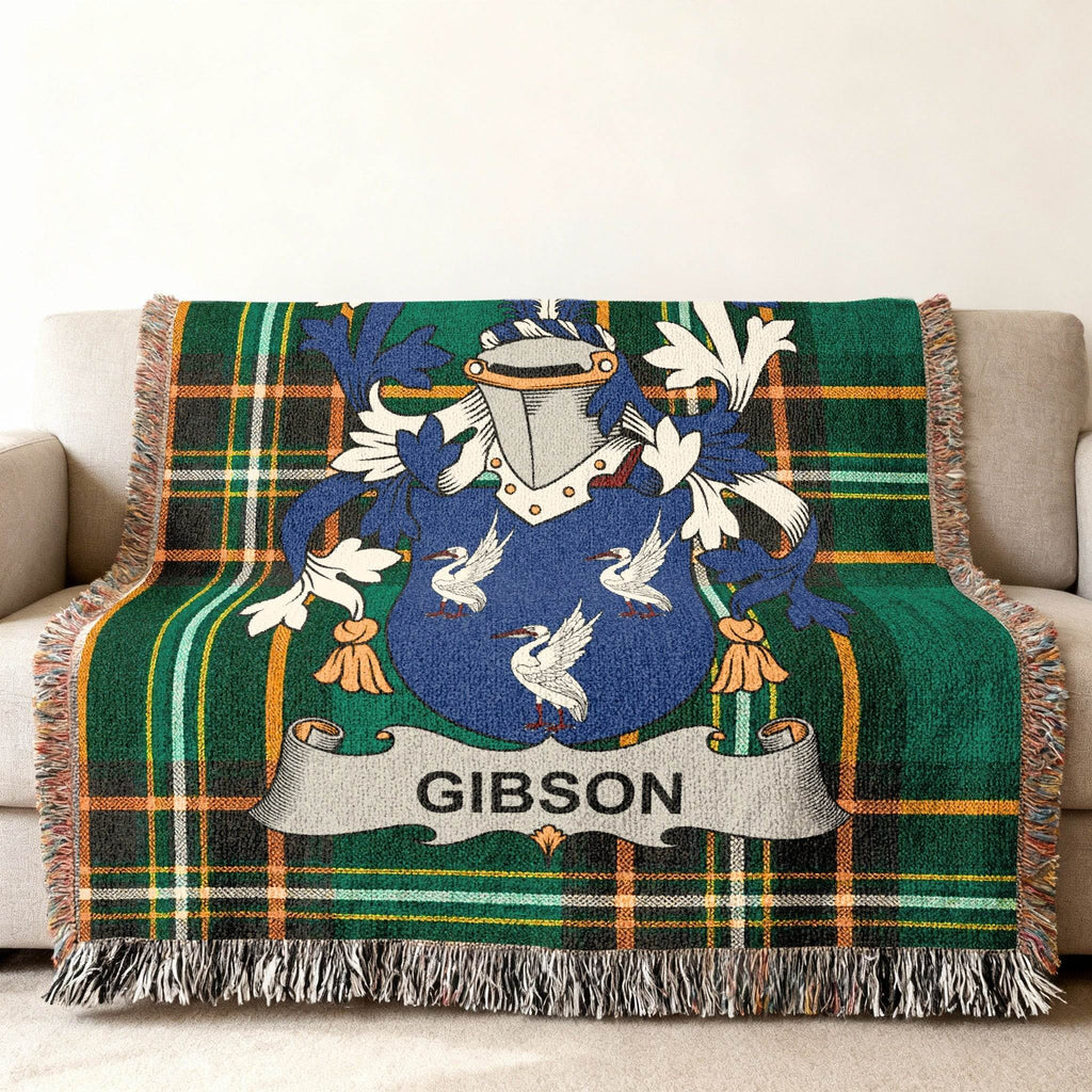 Green plaid throw blanket with Gibson family crest centered on it.