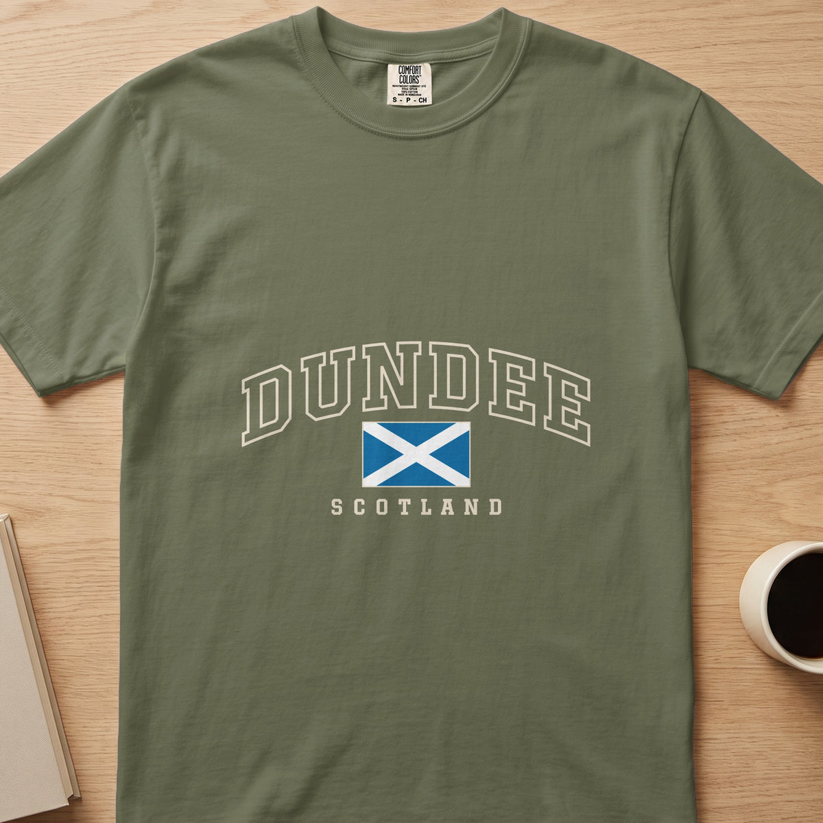 Hemp green Dundee Scotland Comfort Colors T-shirt laid flat, showing the Scottish Saltire front design