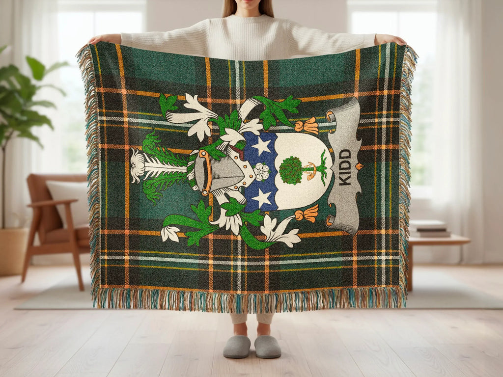 Kidd family crest on a green, black, and orange plaid throw blanket.