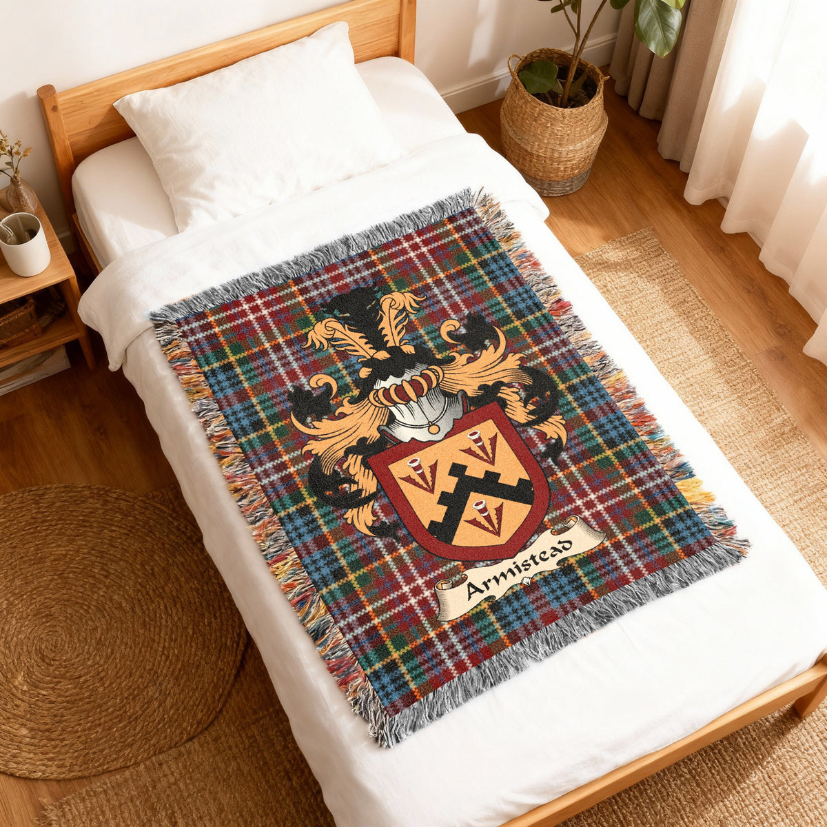 Armistead Scottish family shield woven blanket with Caledonia tartan background, displayed on a bed