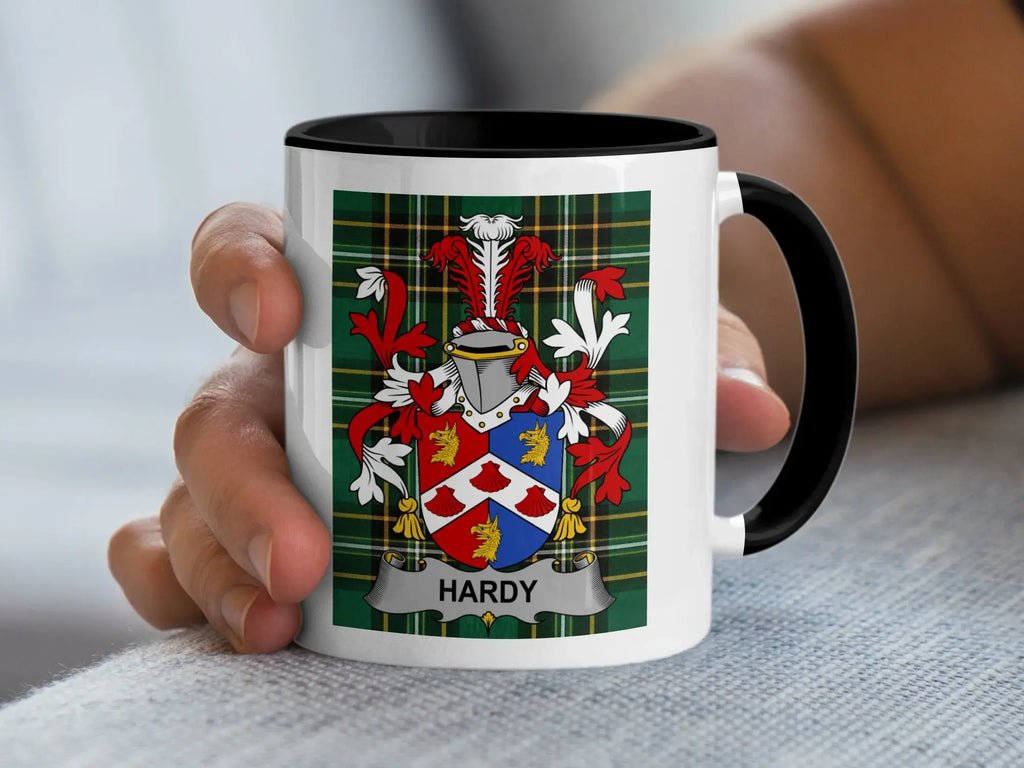 White mug with black handle displaying the Hardy family crest on tartan background.