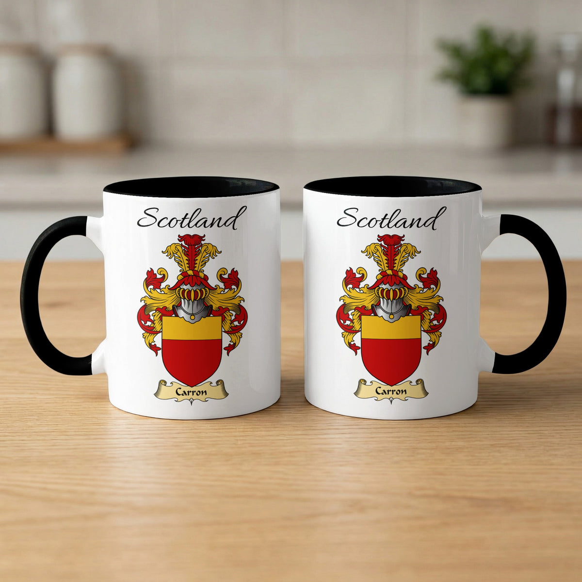Pair of black-accent Carron mugs showing the double-sided Scottish family shield design on white ceramic.