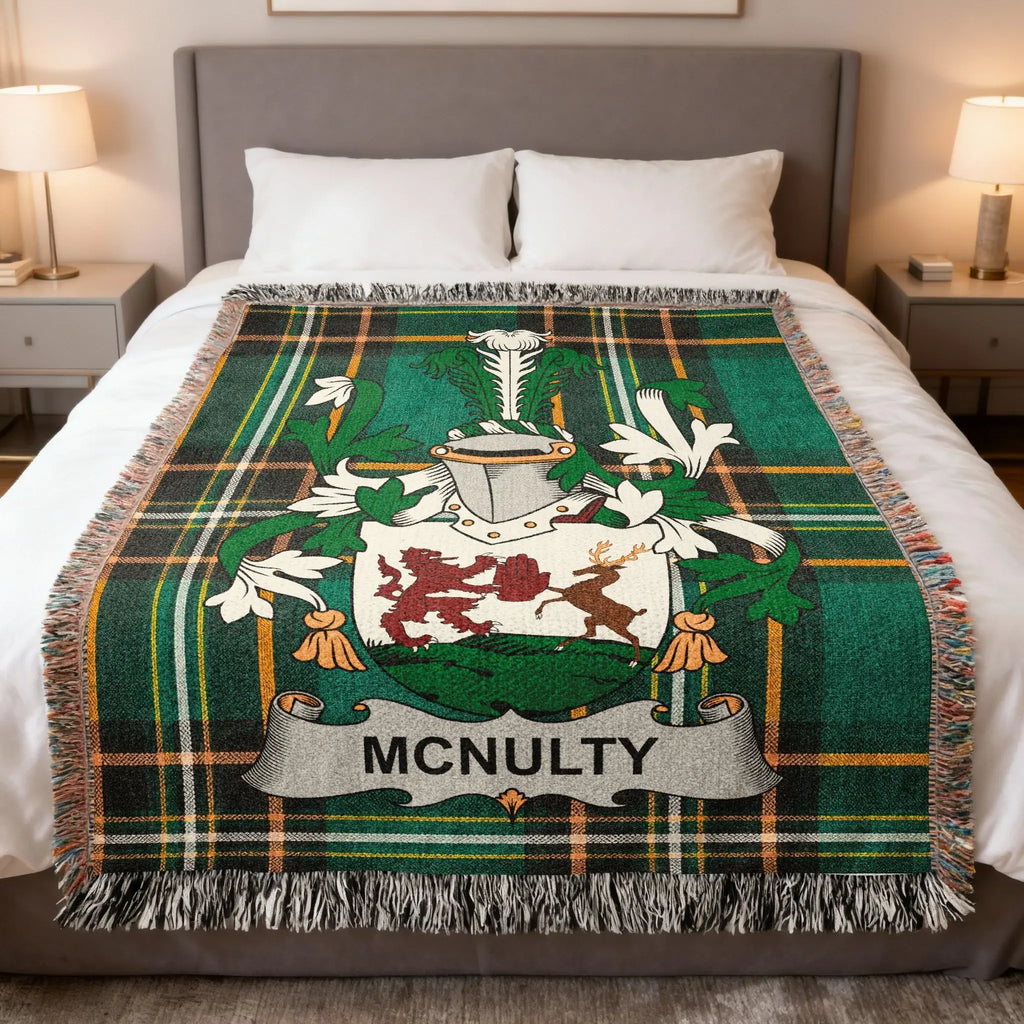 Green tartan blanket with a family crest and "MCNULTY" text draped on a bed.