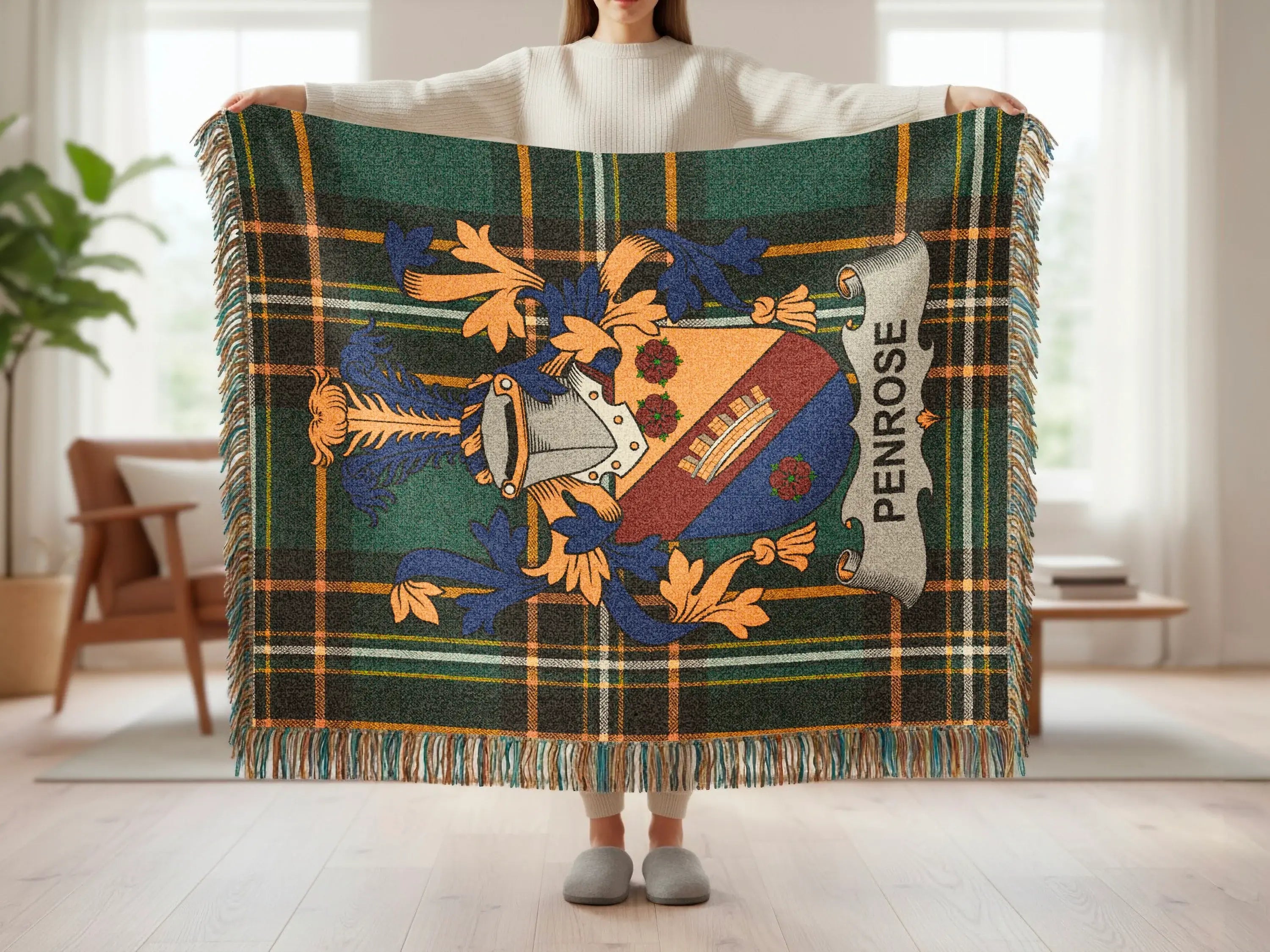 Tartan blanket with Penrose coat of arms and fringe, held by a person.