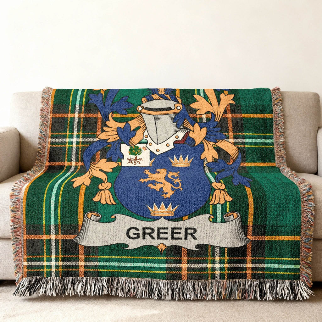 Green tartan blanket with Greer family crest draped on a couch.