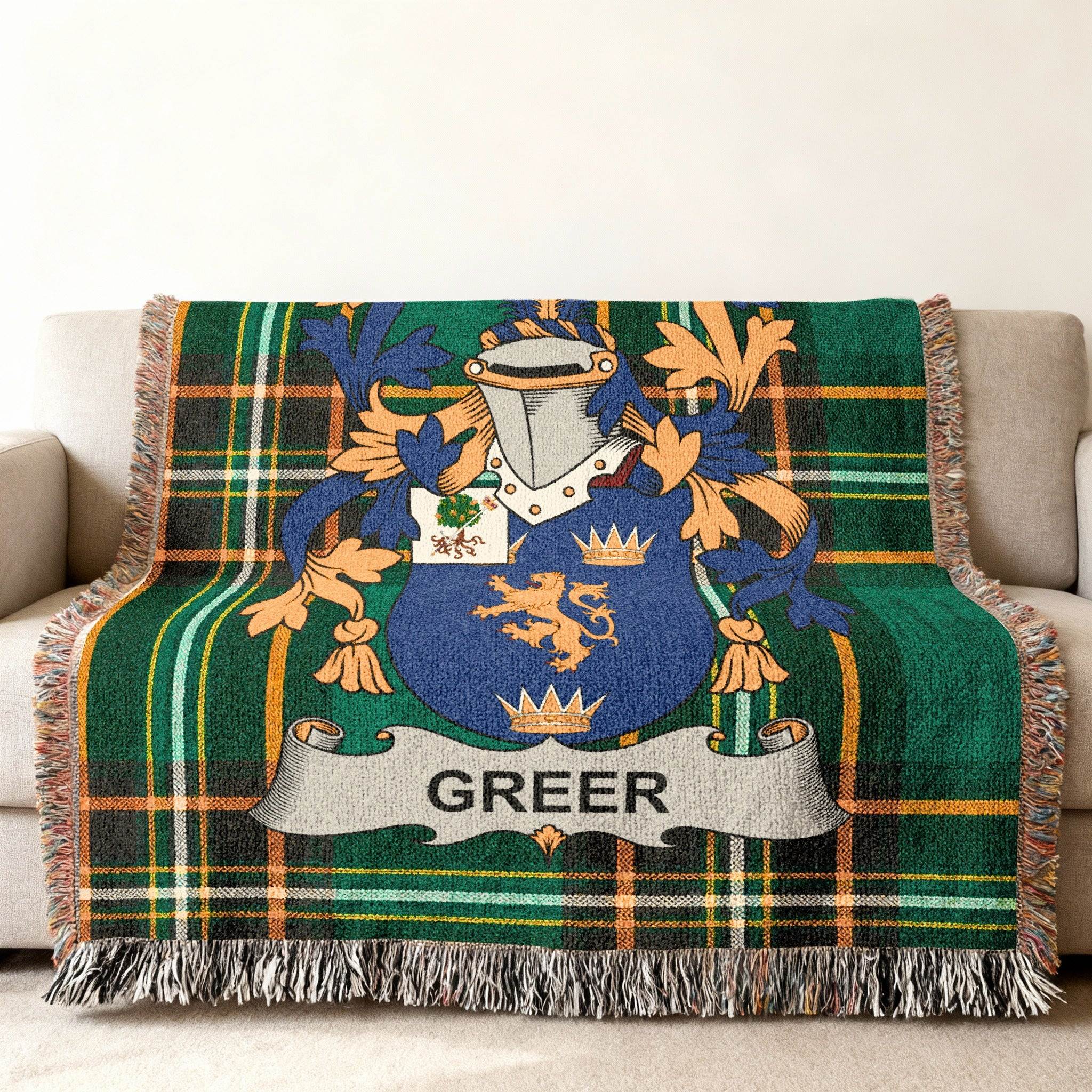 Green tartan blanket with Greer family crest draped on a couch.