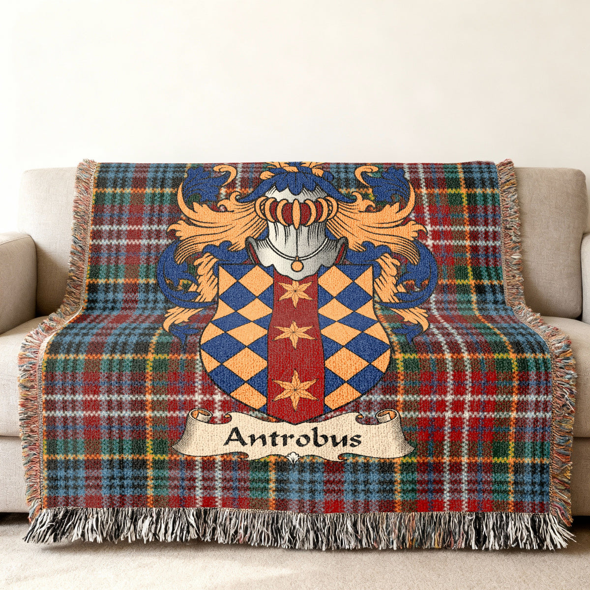 Antrobus Scottish family shield woven blanket with Caledonia tartan background on a sofa