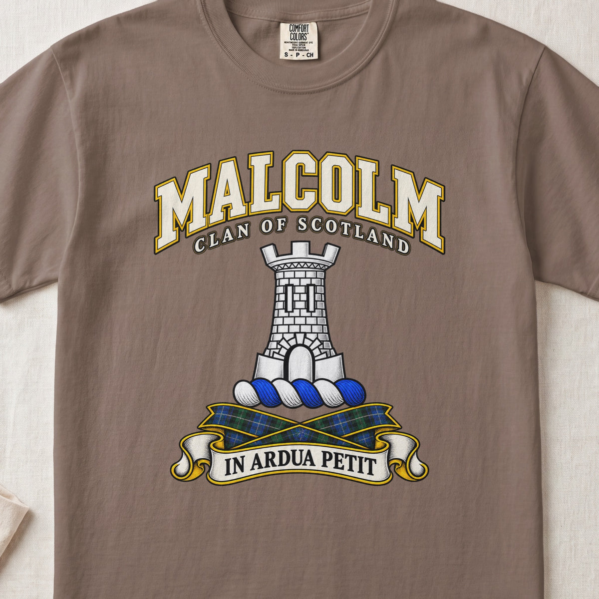 Malcolm Scottish clan T-shirt in Espresso, front view with a gray stone tower and motto banner.