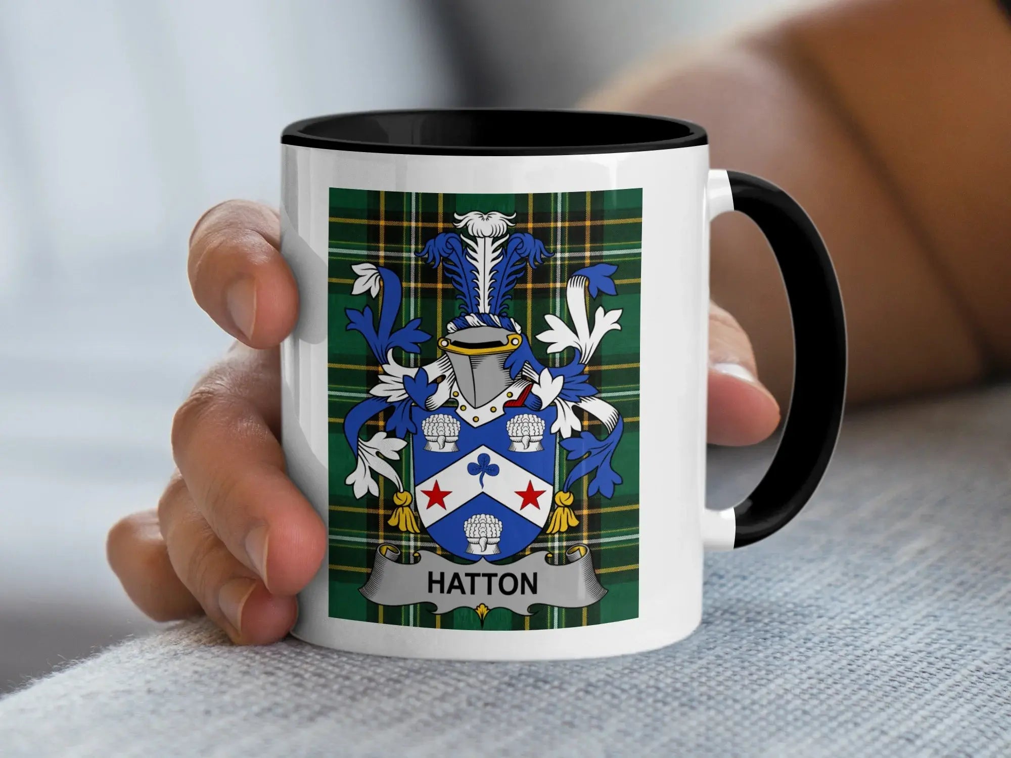 White mug with black rim, featuring Hatton family crest on tartan background.