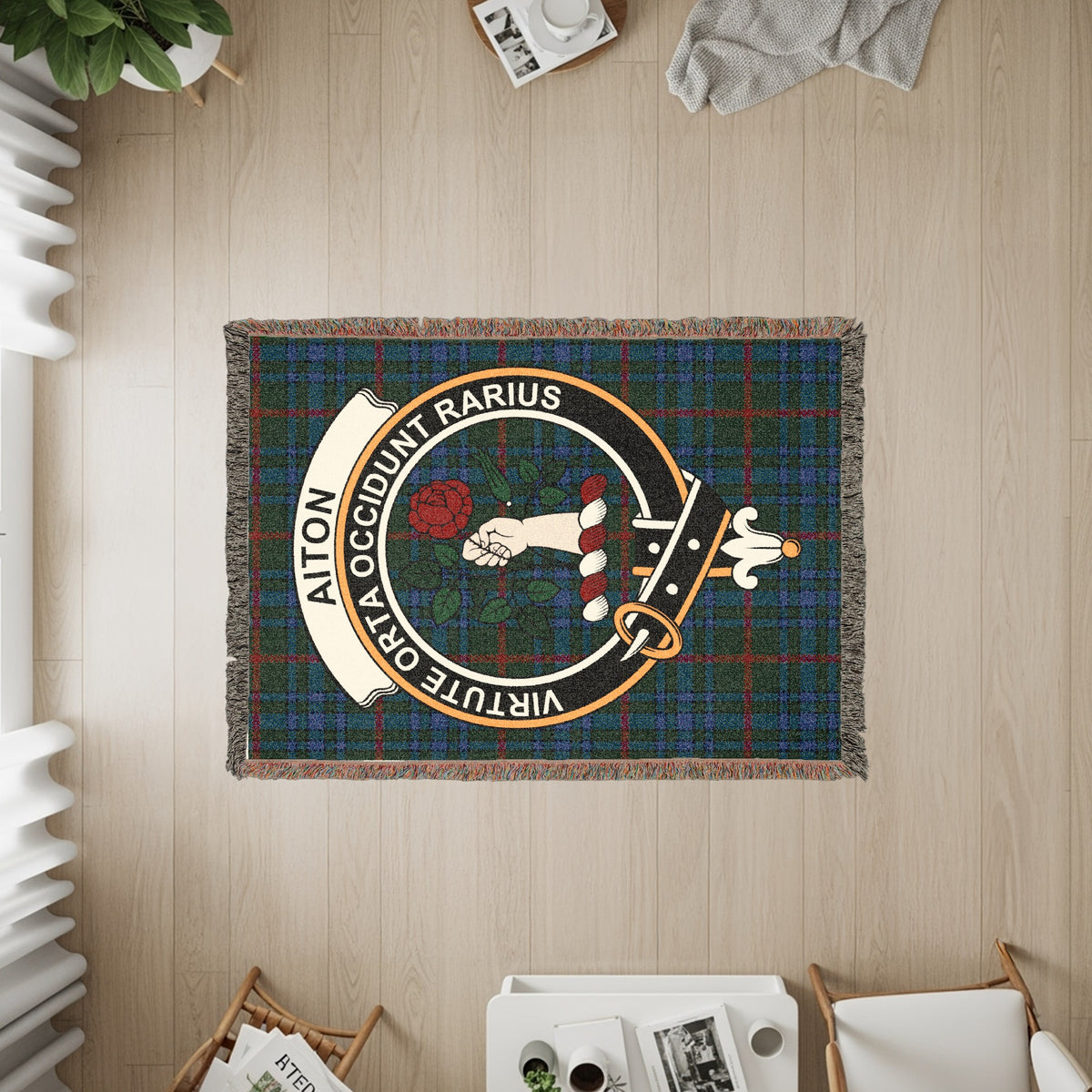 Aiton woven blanket displayed on a wall, featuring the crest badge and tartan background
