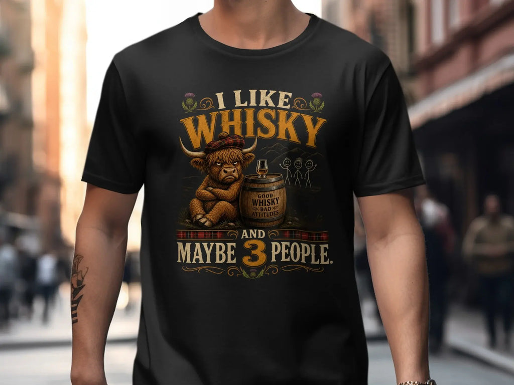 Black t-shirt with a grumpy Highland cow wearing a tartan hat, holding whiskey barrel.