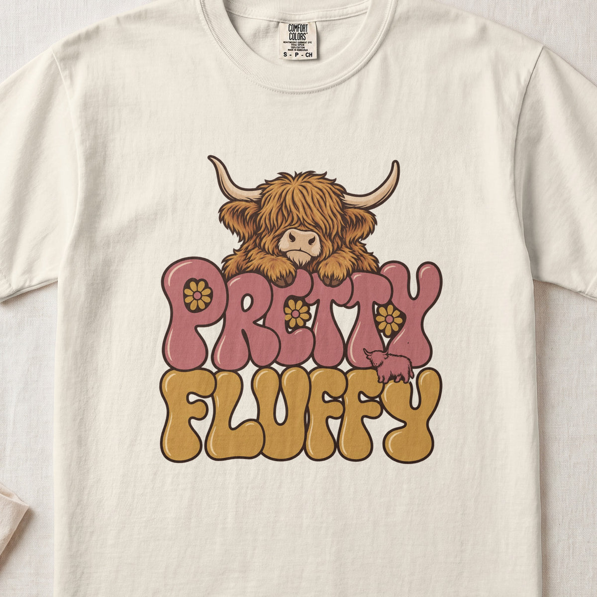 Pretty Fluffy Highland cow design on an Ivory Comfort Colors 1717 T-shirt, flat lay