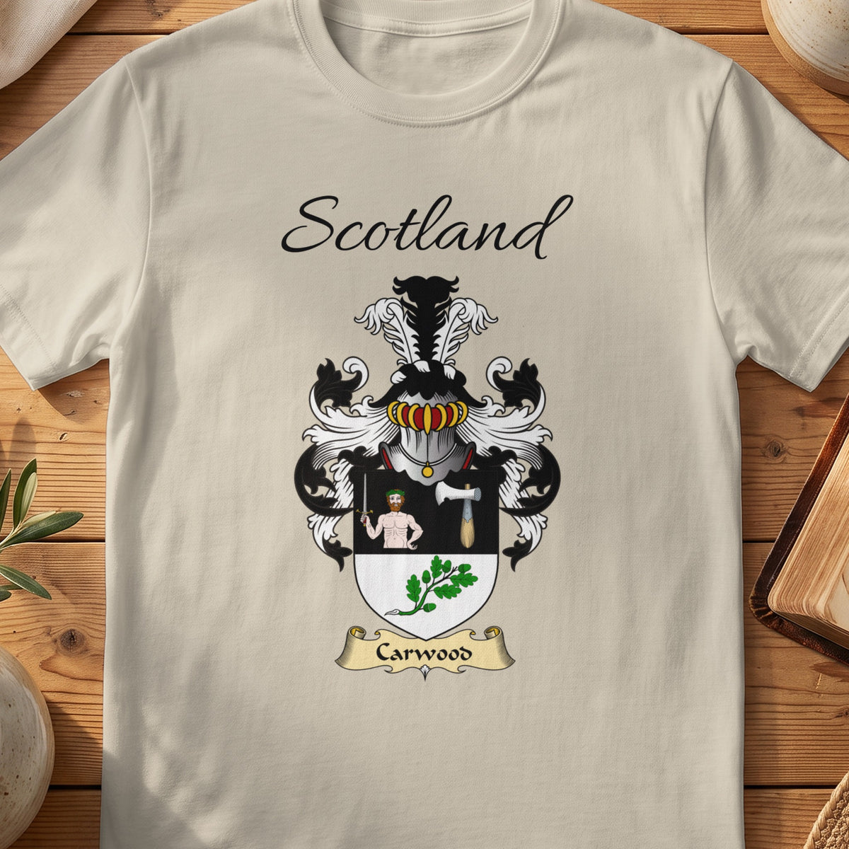 Sand Carwood Scottish family shield T-shirt featuring a human figure and axe above green leaves