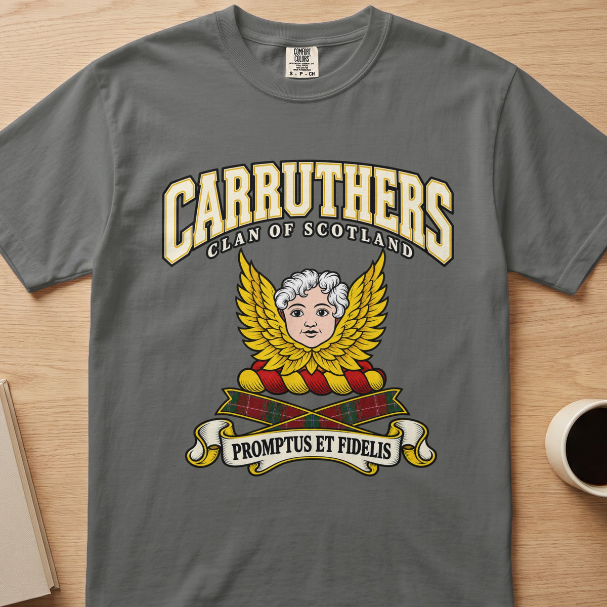 Carruthers pale face framed by golden wings graphic on a charcoal gray Comfort Colors T-shirt, front view