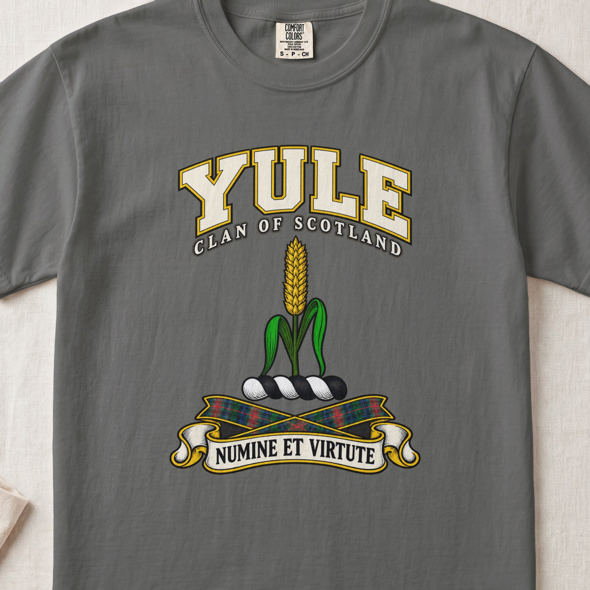 Yule Scottish clan T-shirt in Pepper, front view with a golden ear of grain with green leaves and motto design.