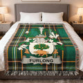 Furlong crest on a green plaid blanket with fringe.