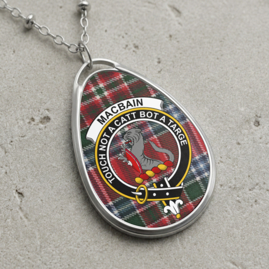 Macbain clan badge necklace with tartan background and motto.