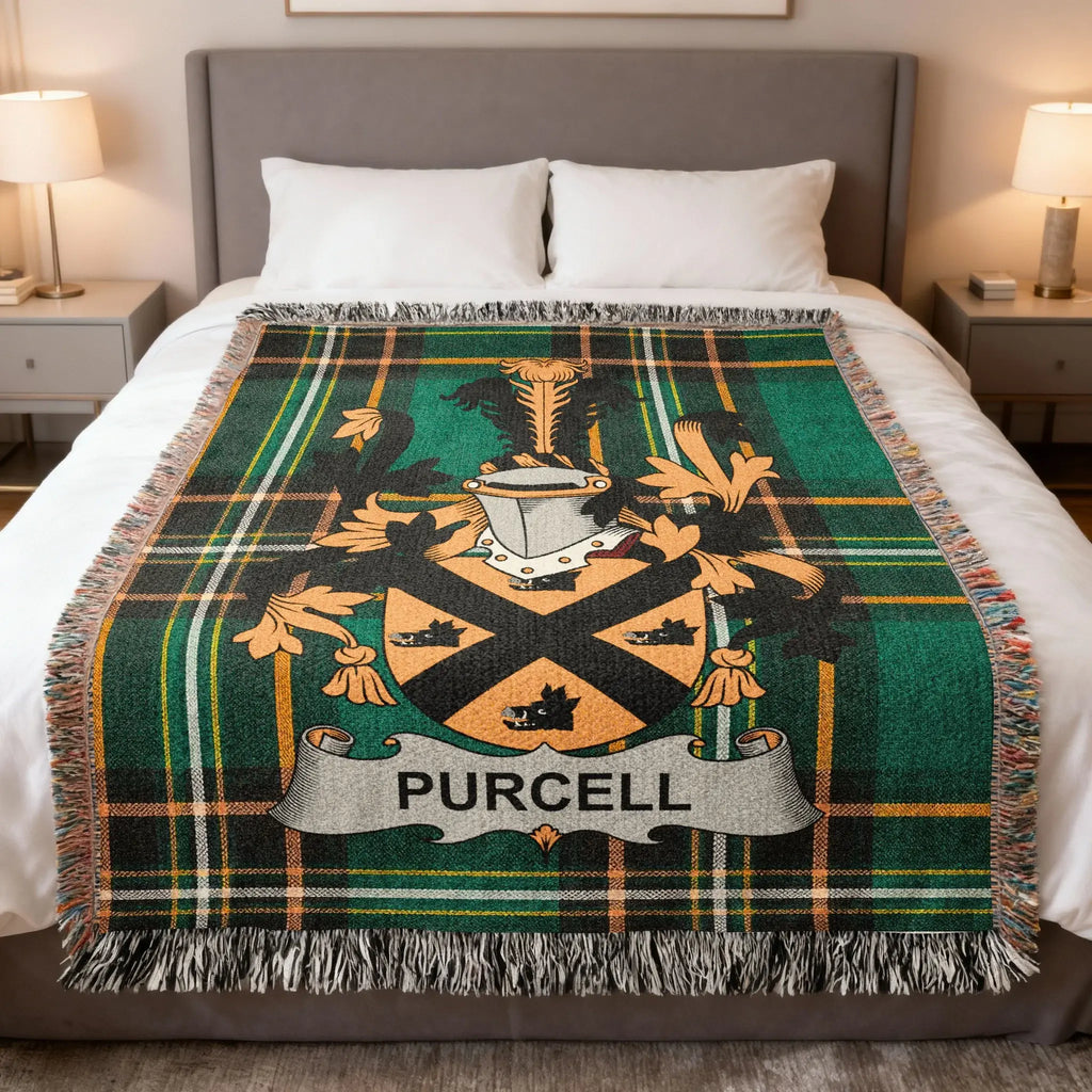 Purcell clan crest on a green plaid wool blanket on a bed.