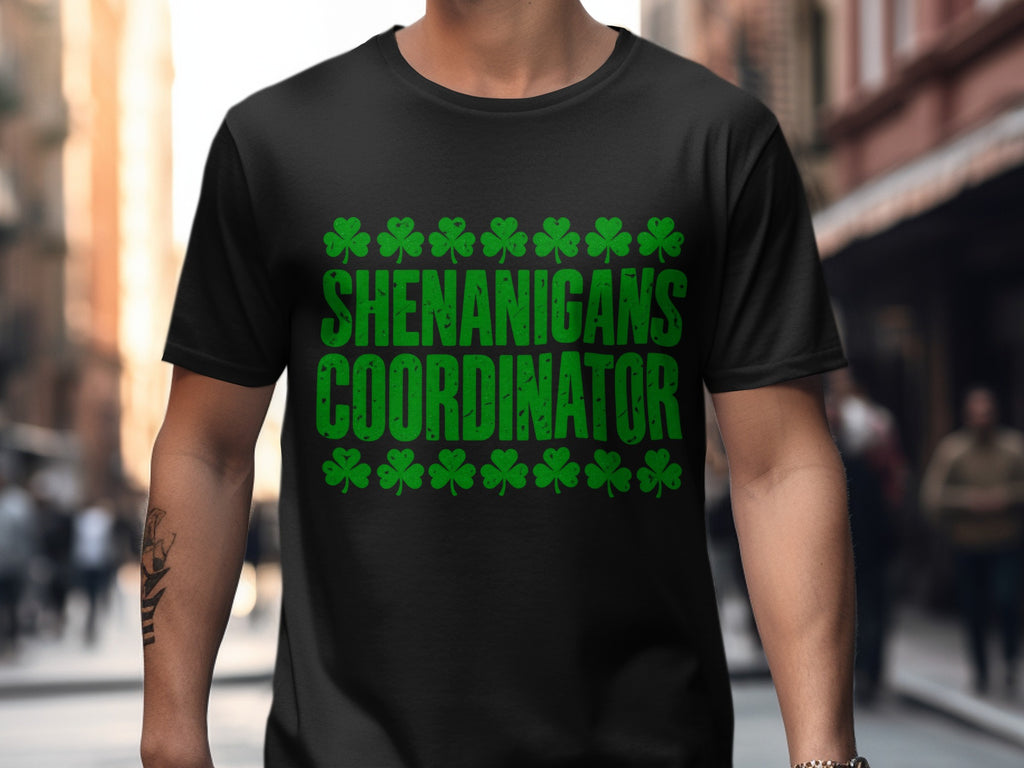 Black T-shirt with “Shenanigans Coordinator” Irish-themed shamrock artwork.