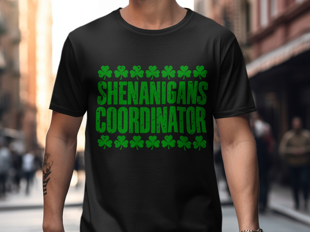 Black T-shirt with “Shenanigans Coordinator” Irish-themed shamrock artwork.