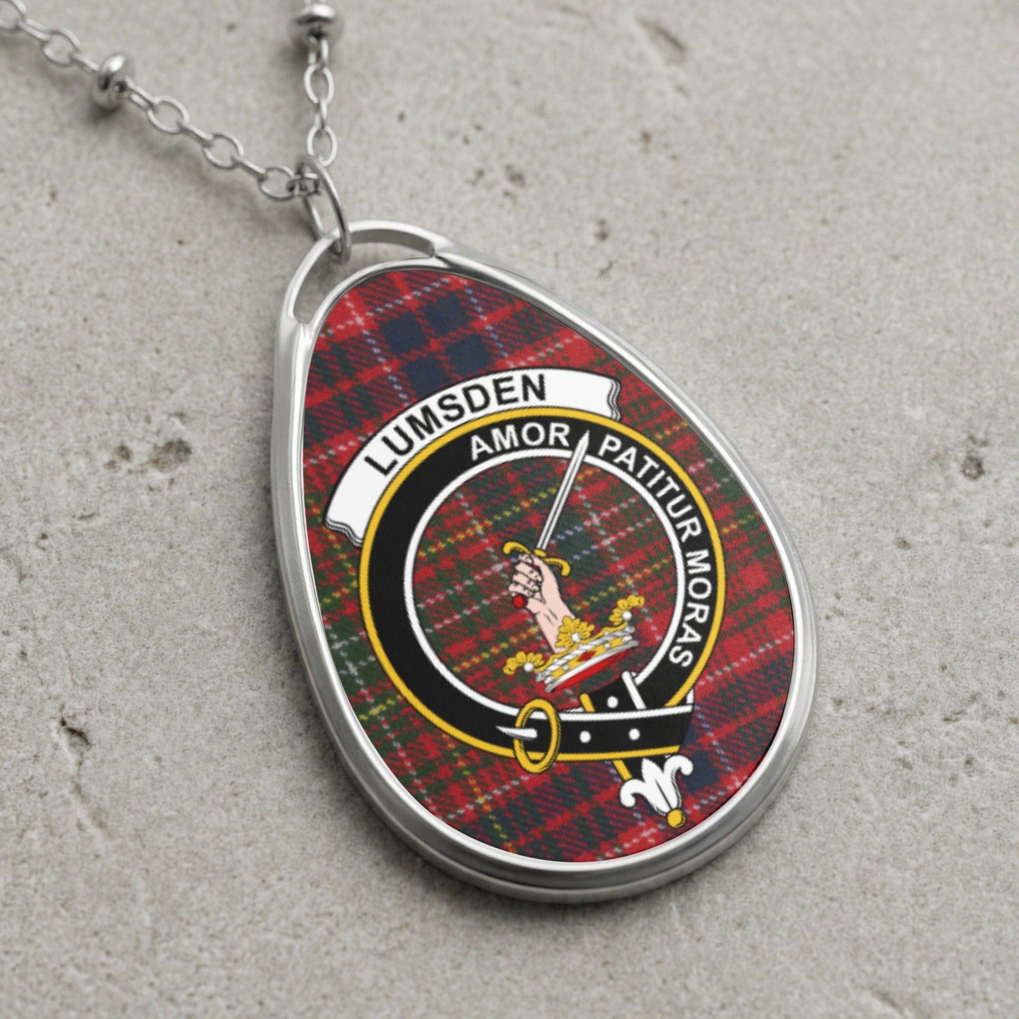 Oval locket necklace with Lumsden tartan and crest featuring a hand holding a sword.