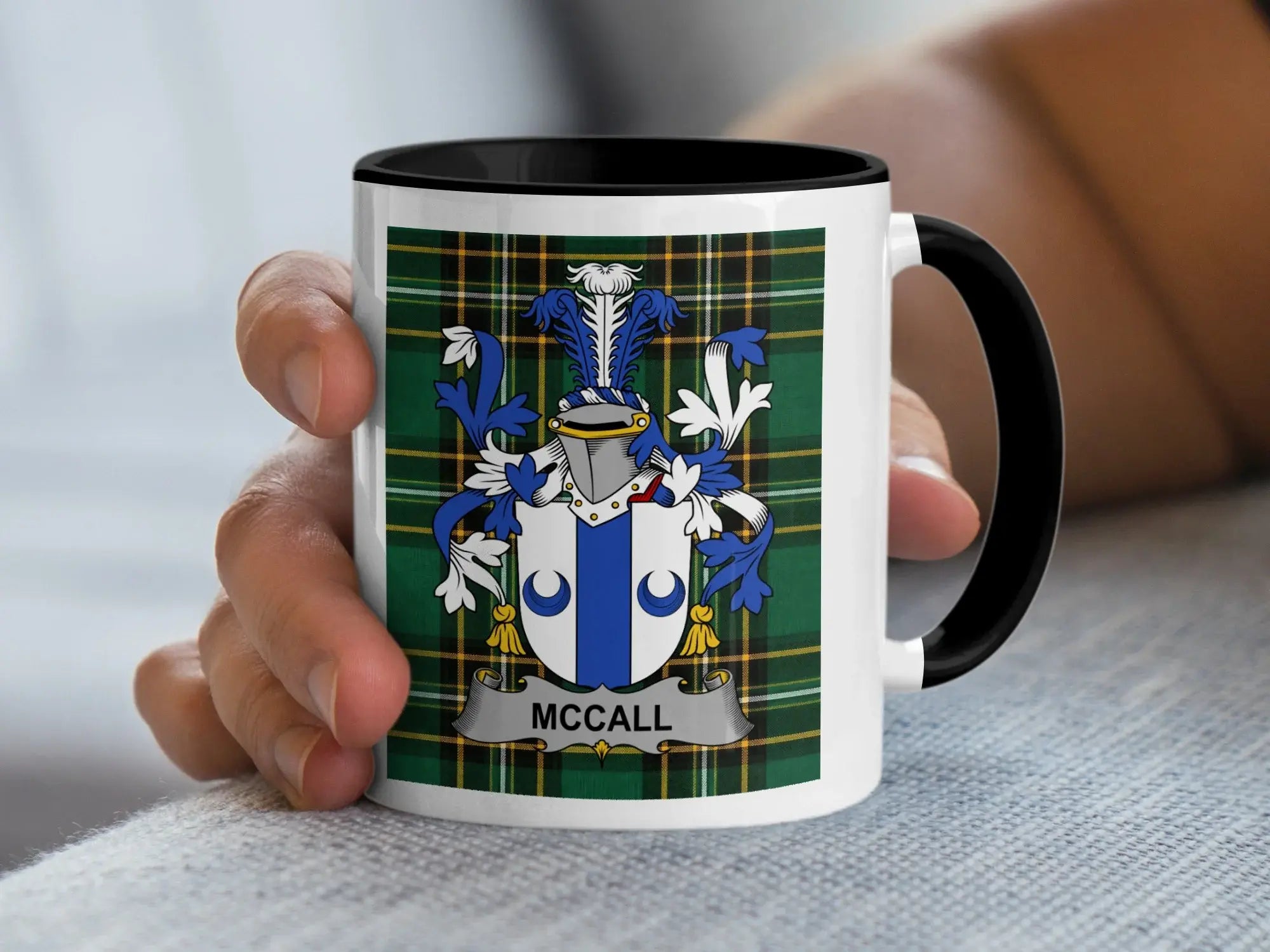 Mug with McCall tartan and coat of arms held by a hand.