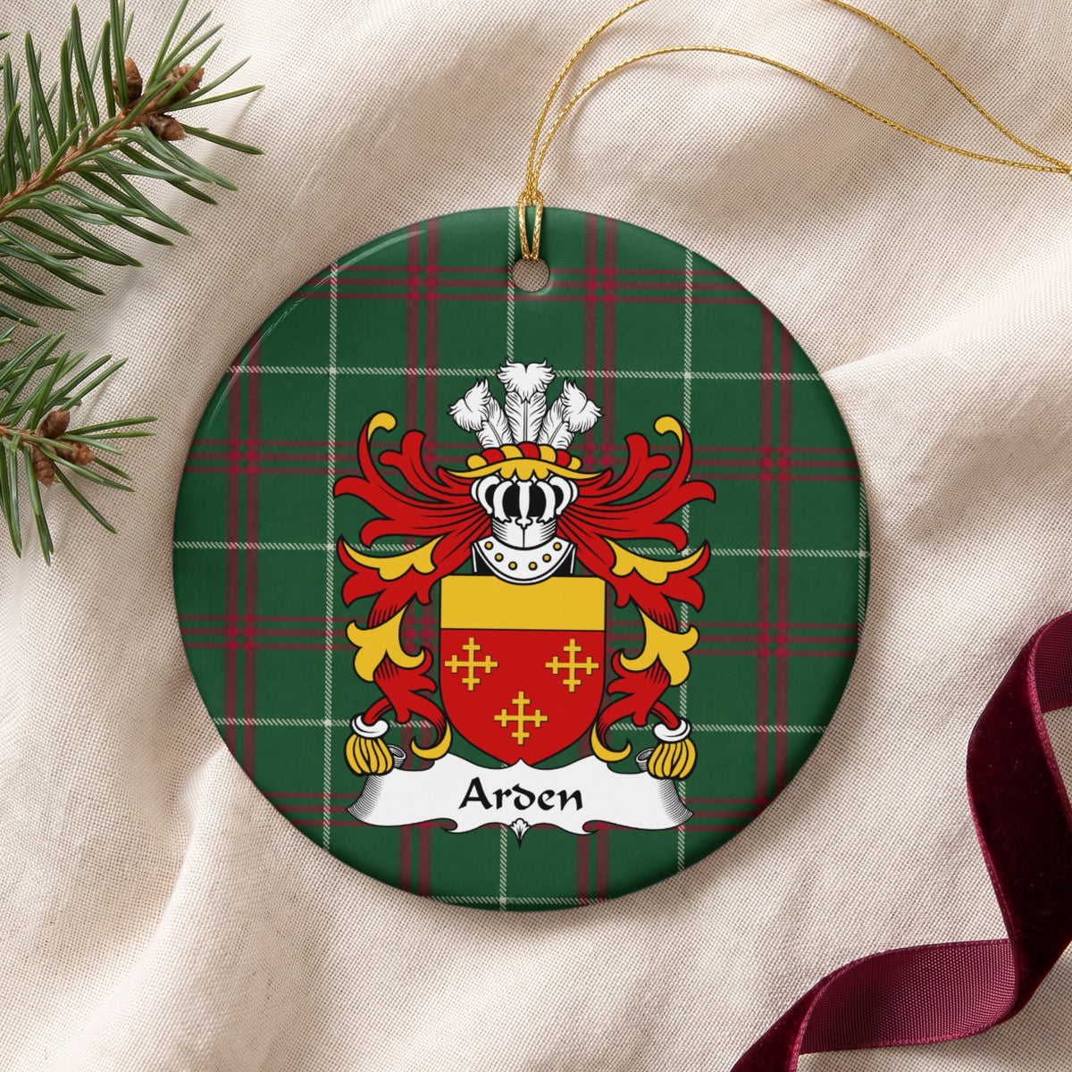 Arden ceramic ornament with gold string on cream fabric; three small gold crosses on red beneath a plain gold top band on Welsh national tartan.